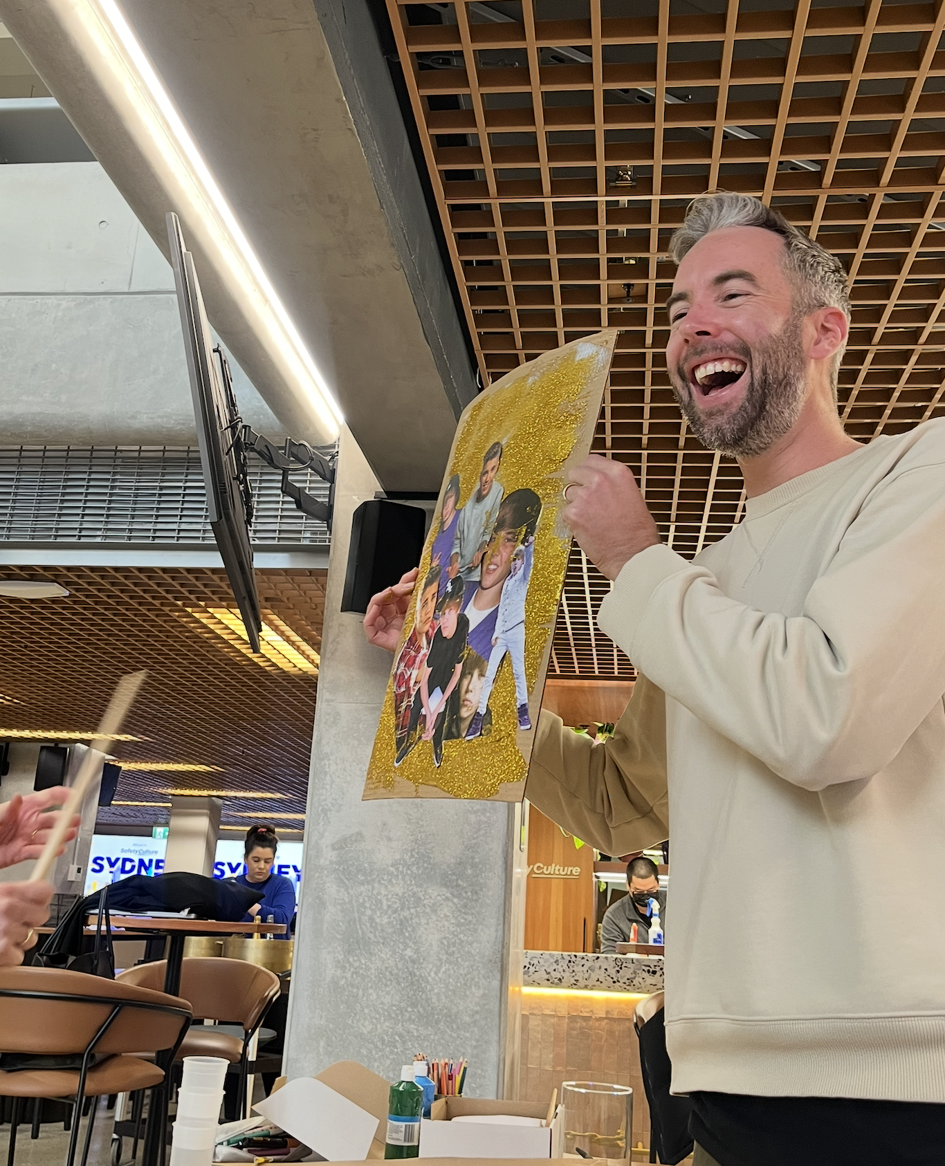 A designer unveiling a glittered Justin Bieber collage